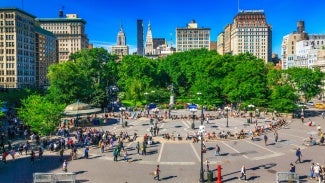 Overview of a park in New York City with hundreds of people