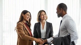 Three business colleagues smiling and shaking hands