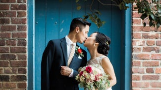 Bride and groom sharing kiss in the courtyard.