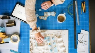 Hands working on an architectural model