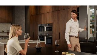 A modern-looking kitchen with two people in it