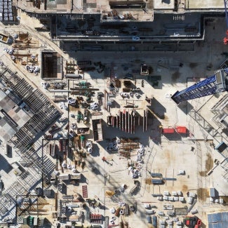 Overhead aerial view of construction cranes at a construction site