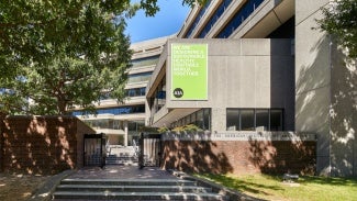 building exterior with a sign that reads we are designing a sustainable, healthy, equitable world, together - AIA