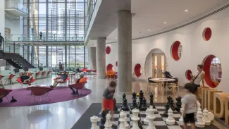 kids play on large chess board in library