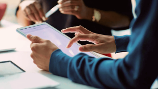 Someone's hands shown using a tablet while at a table