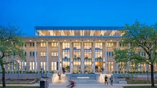 building with columns and a glass facade lit up from inside