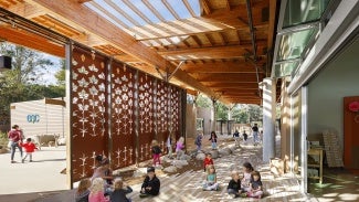 children sitting on floor under large wood patio