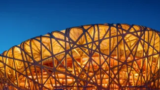 A latticework dome lit up at night