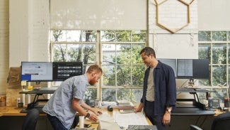 Two people looking at papers on a desk