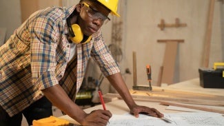 Person with construction helmet and plans