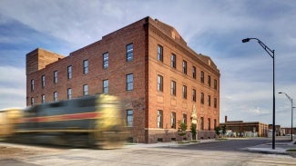 bus in motion moving past brick building