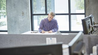 Architect thoughtfully working at draft table