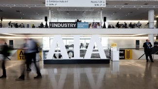 Busy foot traffic in conference center lobby with AIA sign during conference