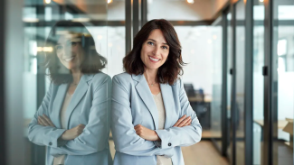 A women standing against a wall in an glass office