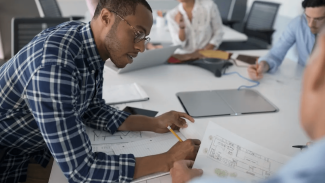 architects sitting around a table looking at plans