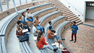 small group of students sitting in a lecture hall with listening to a talk