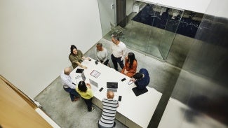 Businesswoman leading project meeting at conference table in office.