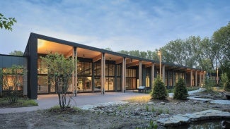 The main lobby and exhibit space opens to a sheltered north terrace, expanding use for events, interpretation, and the public.