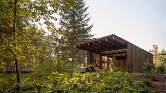 The architecture is deliberately deferential to the landscape, providing a quiet backdrop and flexible gathering space.