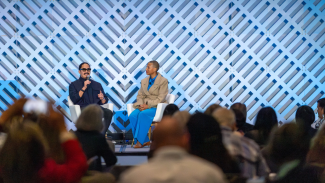 Architects Preeti Sriratana and Kimberly Dowdell sit on a stage sharing a conversation. 