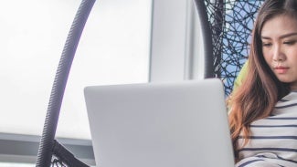 Woman sitting with open laptop