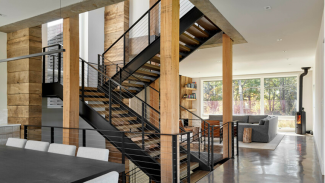 The home’s stair connects with a heat chimney that helps expel hot air and take in cooler air through a venting skylight, much like a cupola would on a historic barn. 