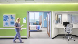 Patient floor corridor featuring patient room and nurses' desk.
