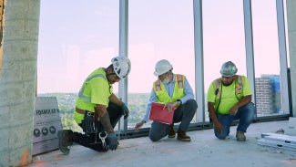 Architect reviewing materials at construction site.
