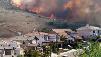 image of a wildfire and homes nearby