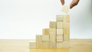 Fingers stacking blocks showing great impact