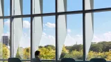 Person sitting by window inside of University of Illinois at Chicago, Academic and Residential Complex (UIC ARC) 