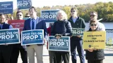 Georgi Ann Bailey holding a Architects for Climate Action sign