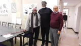 Three men posing for a photo in a conference room