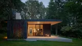 The interior space comes alive in the evening and extends out to the exterior terrace with a large sheltering roof clad in fir planks milled on site.