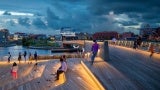 Van Leesten Memorial Bridge at dusk with people sitting on stairs