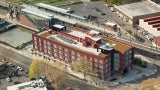 Aerial view of brick residential building next to train tracks