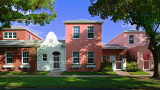 Single family brick rowhouses along a tree-lined street