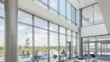 THE DOUBLE-HEIGHT LOBBY ALLOWS AN ABUNDANCE OF NATURAL LIGHT INTO THE ENTRY, PROVIDING VIEWS OUT TO THE CAMPUS.