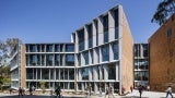 External view of an educational building with large glass windows at day.