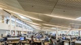 A large open office with wooden ceiling panels.