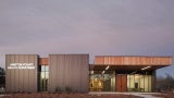 Front elevation of a community health building at dusk. 