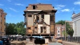 Rear elevation of a historic building sitting up on the lifts. The rear facade is missing. 