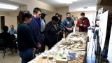 Group of people look at architectural models on a long table