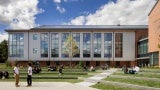 Exterior view of a school with terrace landscaping at daytime. 