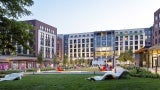 a large grassy square with sculptural elements in a mixed use development.