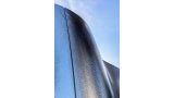 The mottled stainless-steel shell serves as a functional exterior, creating a dynamic appearance that transforms over the course of the day and year with the evolving climate and solar access of its surroundings. The reflective stainless-steel exterior creates an illuminated glow from city and traffic lights and the surrounding palm trees.