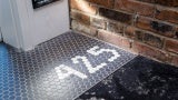 Black tile corner entryway against white tiles that read 425