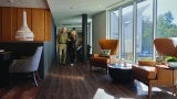 Woman walks with man in a living room space