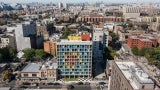 Gridded concrete façade with colorful painted steel panels stands out in