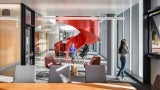 : Conference room with operable window, looking at interior red spiral staircase